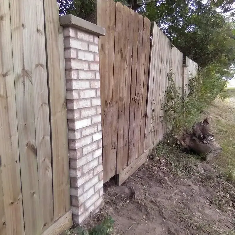 Brick column built into a wood privacy fence