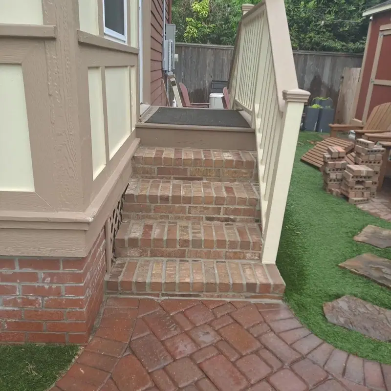 Brick steps rising to a porch, with a herringbone brick landing at the bottom