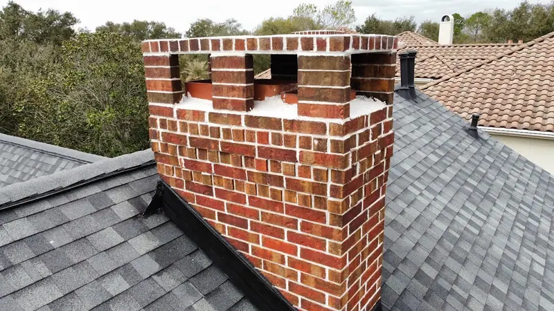Close view of a red brick chimney top being rebuilt, seen from the roof