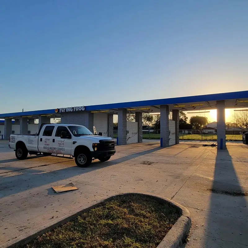 Houston Pro Masonry truck at a commercial car wash at sunset