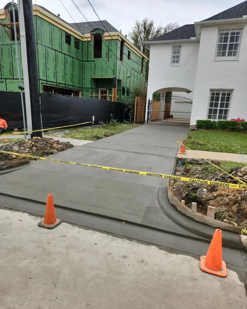 Freshly poured concrete driveway behind safety cones and caution tape