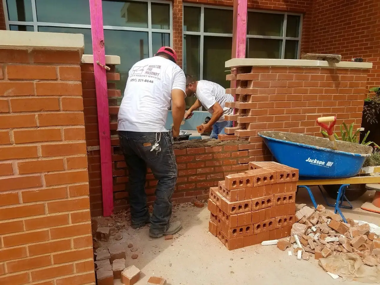 Two Houston Pro Masonry masons building brick porch columns