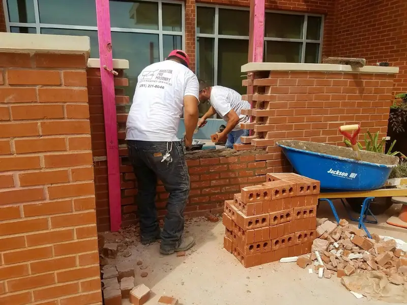 Two Houston Pro Masonry masons building brick porch columns