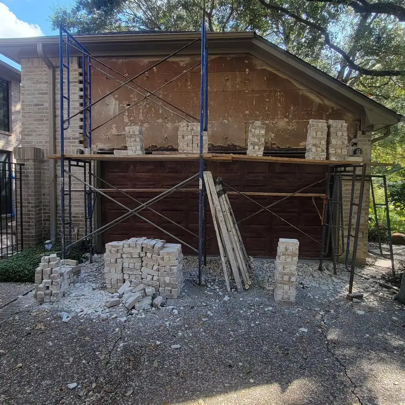 Brick removed above a garage door opening, with scaffolding in place