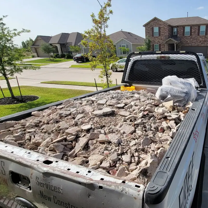 Truck bed loaded with broken concrete and masonry debris for haul-off
