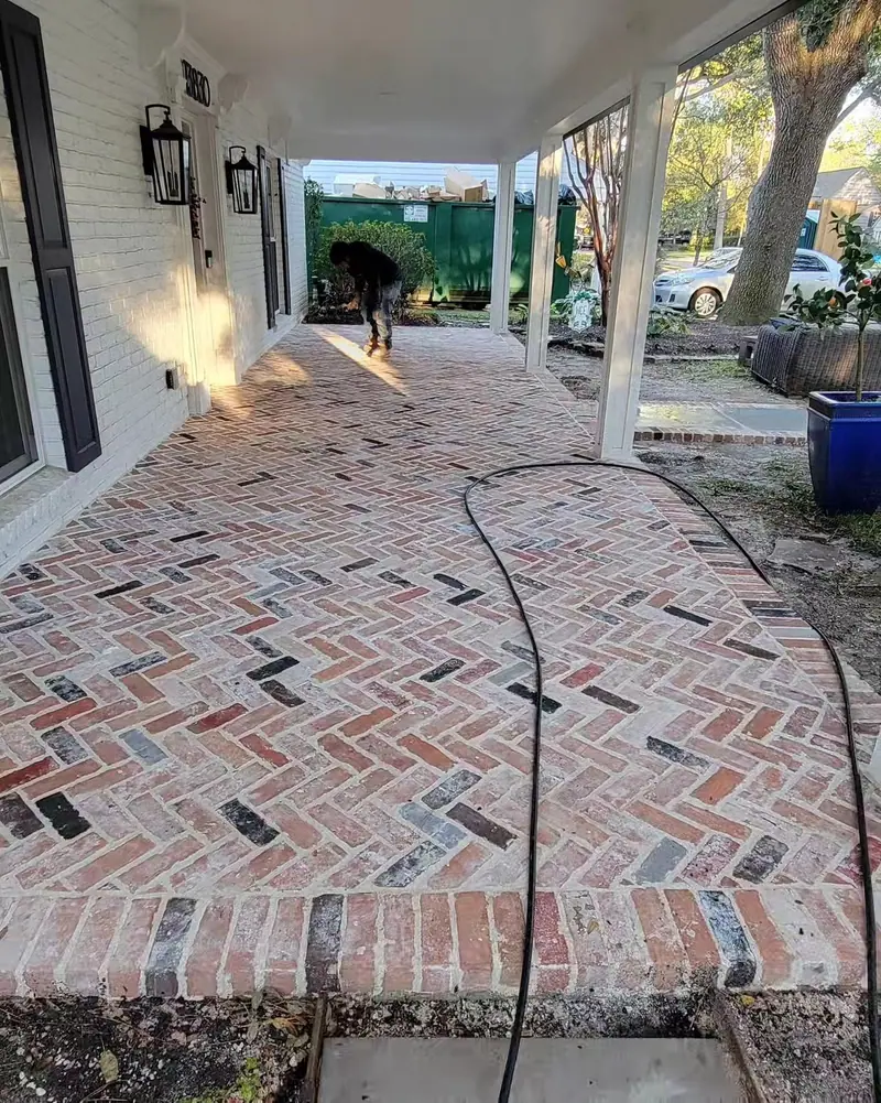 Finished herringbone brick floor running the length of a covered front porch