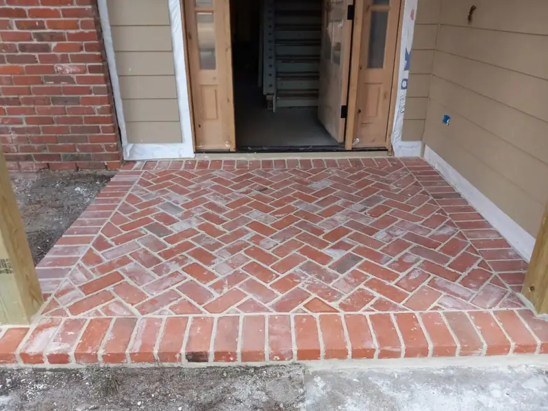 Finished herringbone brick entry landing and step