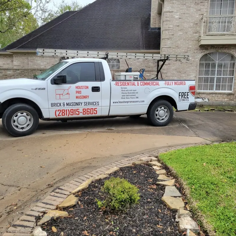Houston Pro Masonry work truck with the company logo and phone number on the door