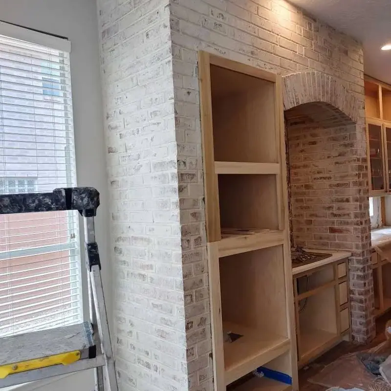Light-finished interior brick wall beside built-in shelving