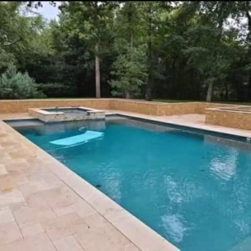 Pool deck and coping laid in light stone pavers