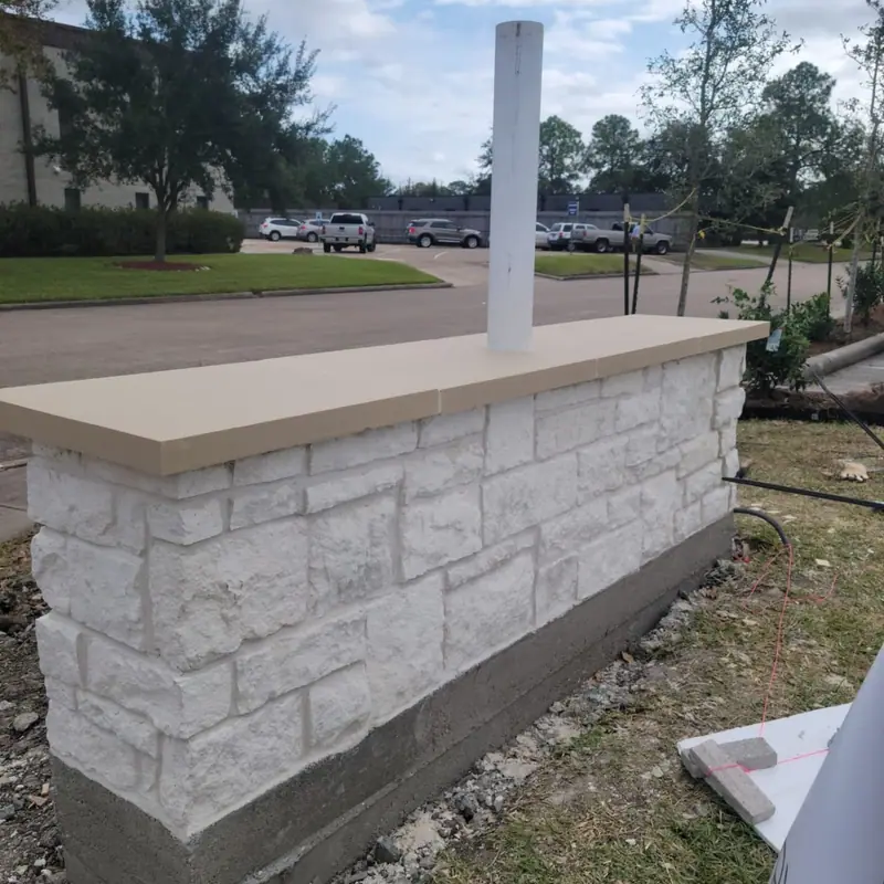 White stone block wall with a precast cap, newly built