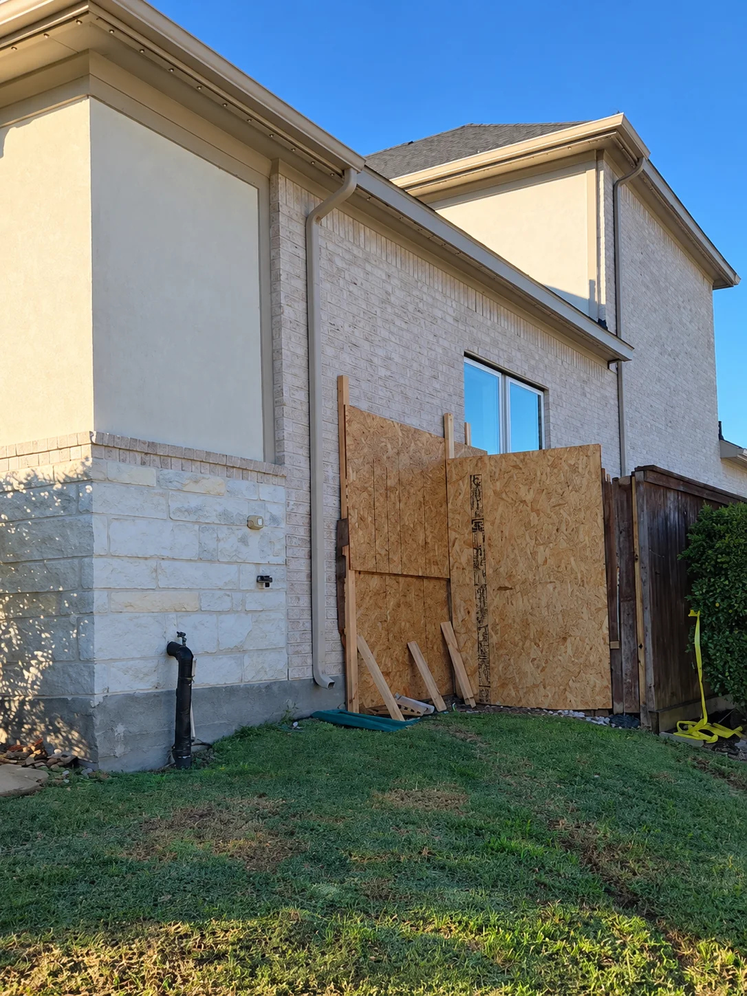 Plywood emergency board-up protecting an opening in a brick home