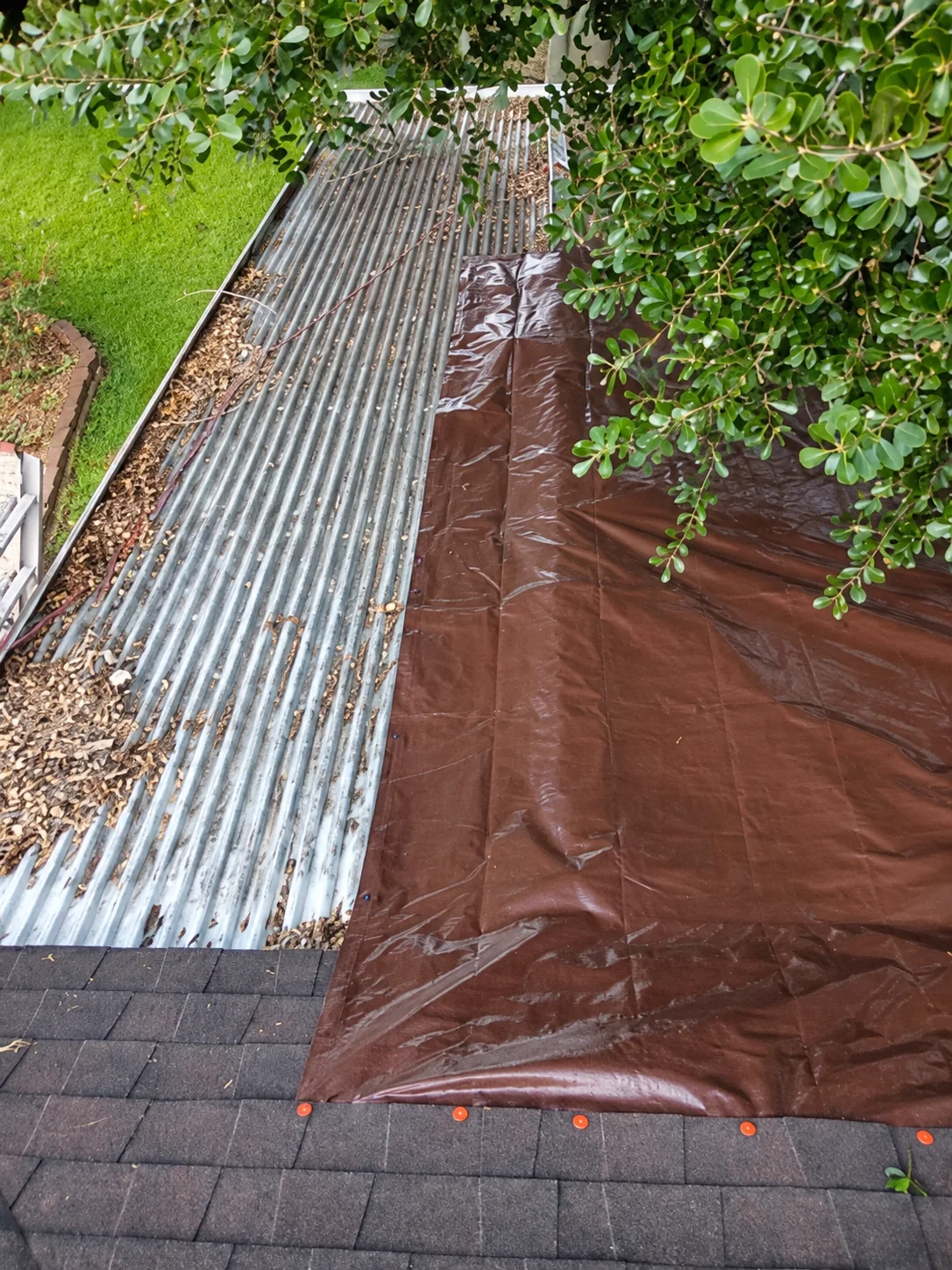 Brown temporary roof tarp covering an exposed roof section